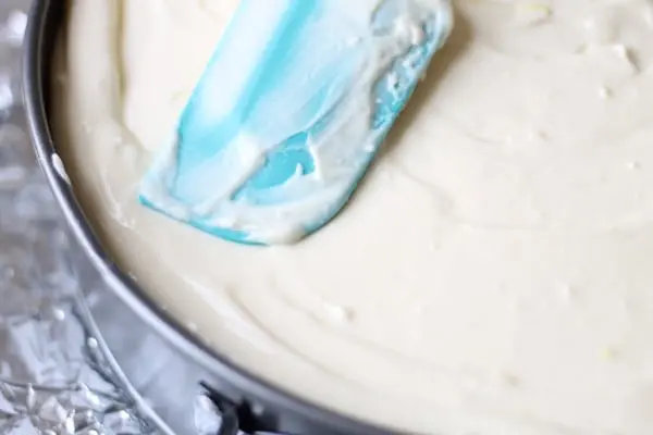 smoothing cheesecake batter in a pan