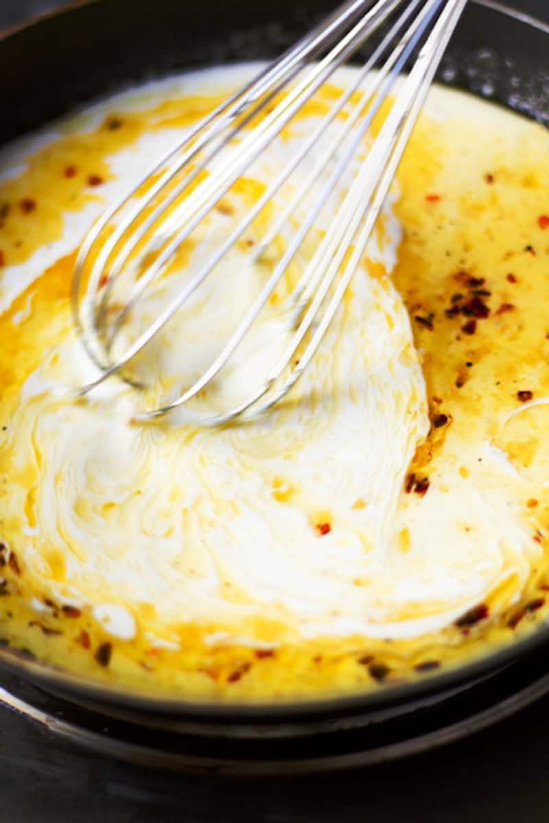whisking cream and butter in a sauce pan