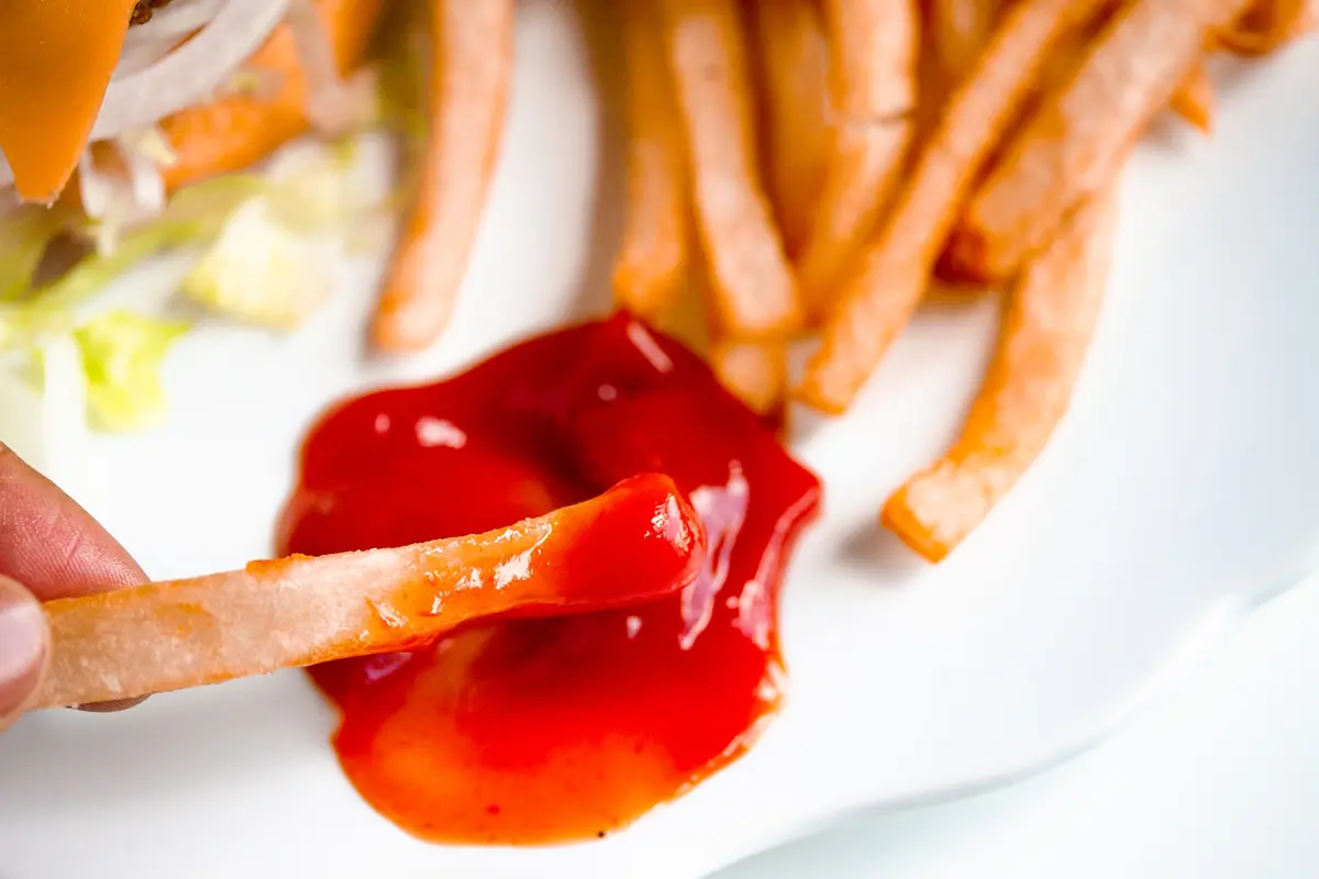 crispy french fries dipped in ketchup