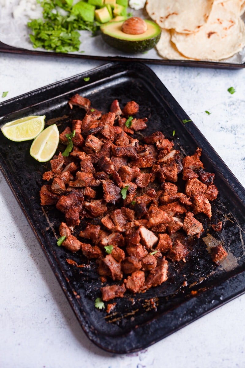 cooked chopped pork with lime wedges