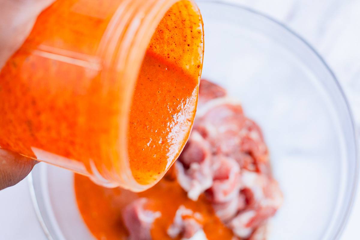 spicy marinade poured over sliced pork